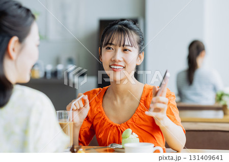 カフェでスマホを持って話す若い女性 カフェでスマホを持って話す若い女性 131409641