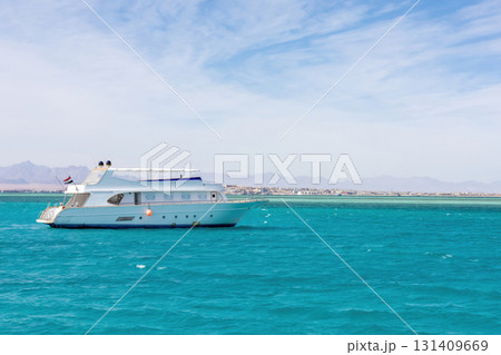 Luxurious white yacht sailing on crystal blue sea under clear sky Luxurious white yacht sailing on crystal blue sea under clear sky 131409669