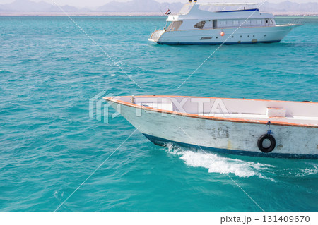 Idyllic coastal scene with white boats on turquoise waters in a tranquil seascape Idyllic coastal scene with white boats on turquoise waters in a tranquil seascape 131409670
