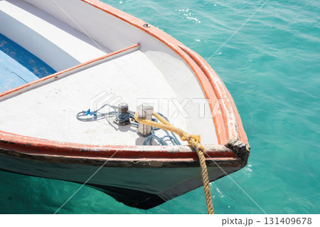 Peaceful day on a turquoise sea with a moored boat in tropical waters Peaceful day on a turquoise sea with a moored boat in tropical waters 131409678