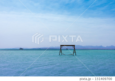 Tranquil seascape with hammock and clear blue skies for relaxation and escape Tranquil seascape with hammock and clear blue skies for relaxation and escape 131409700