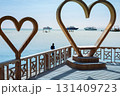 Scenic coastal view with wooden heart sculptures overlooking the ocean horizon 131409723