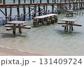 Tranquil seaside pier with wooden tables and crystal clear water for relaxation  131409724