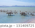 Tranquil coastal scene with rustic wooden fences and tables in shallow water 131409725