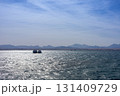 Tranquil seascape with distant mountain range under clear sky 131409729