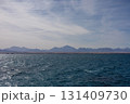 Serene ocean view with distant mountain range and clear sky 131409730