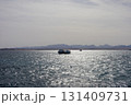 Tranquil ocean view with boats on a sparkling water horizon 131409731
