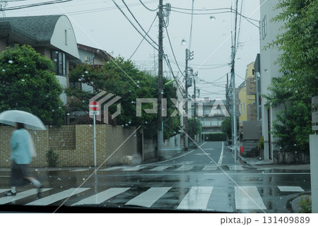 雨の日の道路を散歩する人 131409889