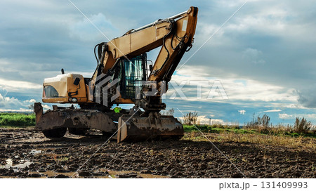Yellow excavator parked on Yellow excavator parked on 131409993