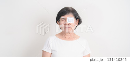 Elderly Woman with Eye protecting by Eye Pad for concepts of Eye disease, Cataract, Glaucoma, Age Related Macular Degeneration, Diabetic Retinopathy, Vitreous, Conjunctivitis, World Glaucoma day Elderly Woman with Eye protecting by Eye Pad for concepts of Eye disease, Cataract, Glaucoma, Age Related Macular Degeneration, Diabetic Retinopathy, Vitreous, Conjunctivitis, World Glaucoma day 131410243