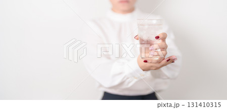 Business woman having Tremor hand during hold water glass. Parkinson disease April awareness month, Carpal Tunnel Syndrome, rheumatoid and brain injury, Neurological disorder and health care concept Business woman having Tremor hand during hold water glass. Parkinson disease April awareness month, Carpal Tunnel Syndrome, rheumatoid and brain injury, Neurological disorder and health care concept 131410315
