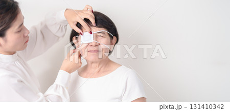 Elderly Woman with Eye protecting by Eye Pad for concepts of Eye disease, Cataract, Glaucoma, Age Related Macular Degeneration, Diabetic Retinopathy, Vitreous, Conjunctivitis, World Glaucoma day Elderly Woman with Eye protecting by Eye Pad for concepts of Eye disease, Cataract, Glaucoma, Age Related Macular Degeneration, Diabetic Retinopathy, Vitreous, Conjunctivitis, World Glaucoma day 131410342
