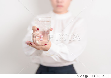 Business woman having Tremor hand during hold water glass. Parkinson disease April awareness month, Carpal Tunnel Syndrome, rheumatoid and brain injury, Neurological disorder and health care concept 131410462