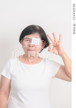 Elderly Woman with Eye protecting by Eye Pad for concepts of Eye disease, Cataract, Glaucoma, Age Related Macular Degeneration, Diabetic Retinopathy, Vitreous, Conjunctivitis, World Glaucoma day Elderly Woman with Eye protecting by Eye Pad for concepts of Eye disease, Cataract, Glaucoma, Age Related Macular Degeneration, Diabetic Retinopathy, Vitreous, Conjunctivitis, World Glaucoma day 131410530