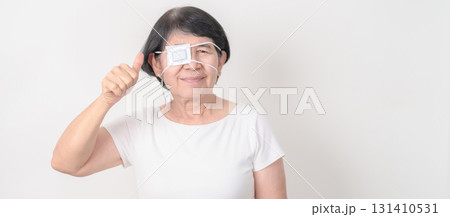 Elderly Woman with Eye protecting by Eye Pad for concepts of Eye disease, Cataract, Glaucoma, Age Related Macular Degeneration, Diabetic Retinopathy, Vitreous, Conjunctivitis, World Glaucoma day 131410531