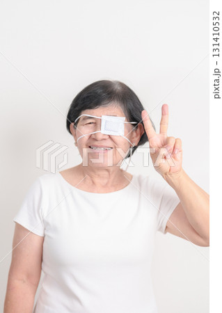 Elderly Woman with Eye protecting by Eye Pad for concepts of Eye disease, Cataract, Glaucoma, Age Related Macular Degeneration, Diabetic Retinopathy, Vitreous, Conjunctivitis, World Glaucoma day 131410532