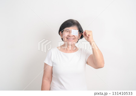 Elderly Woman with Eye protecting by Eye Pad for concepts of Eye disease, Cataract, Glaucoma, Age Related Macular Degeneration, Diabetic Retinopathy, Vitreous, Conjunctivitis, World Glaucoma day Elderly Woman with Eye protecting by Eye Pad for concepts of Eye disease, Cataract, Glaucoma, Age Related Macular Degeneration, Diabetic Retinopathy, Vitreous, Conjunctivitis, World Glaucoma day 131410533