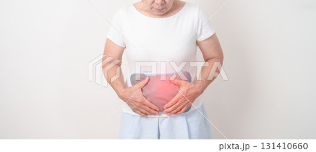 Elderly woman having abdomen aches with Hot Water Bottle Bag for Pain Relief for Stomach pain, digestion with constipation or Diarrhea from food poisoning, Stomachache and health care concepts 131410660