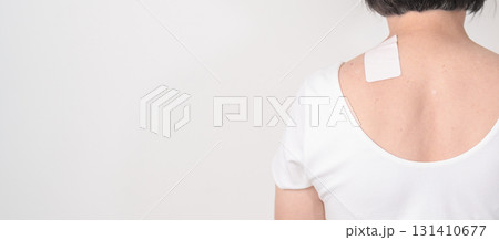Elderly Woman having Shoulder Pain with Medicated pain relief patch plaster for Muscle Inflammation and Sprain, Myofascial ache syndrome and Fibromyalgia, Shoulder Myalgia and Scapular Tightness 131410677