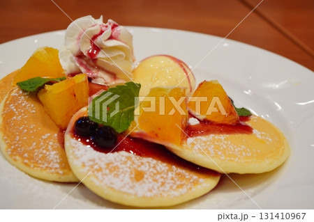 オレンジとブルーベリーにホイップクリームを添えたカフェスイーツ風のパンケーキを撮影した洋菓子デザート 131410967