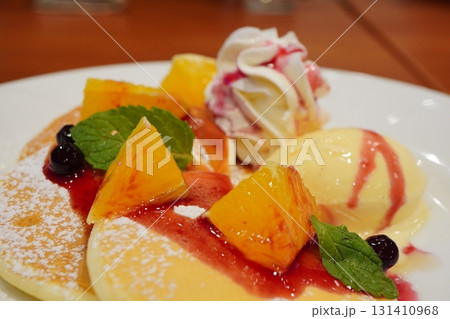 バニラアイスとホイップクリームにオレンジを添えたパンケーキをクローズアップで撮影したカフェデザート 131410968
