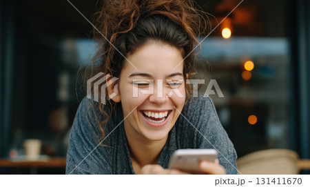 Smiling woman relaxing on sofa with smartphone, enjoying a joyful carefree moment 131411670