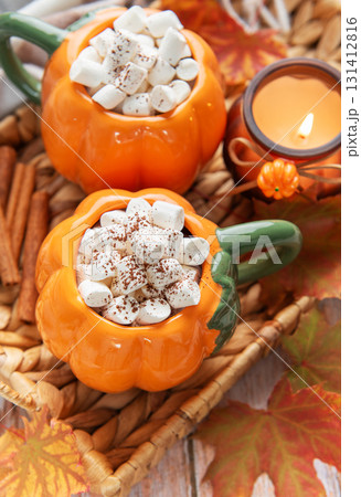 Pumpkin mugs with hot chocolate for autumn cozy warmth 131412816