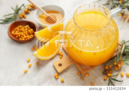 Warming sea buckthorn tea with orange slices and honey 131412834