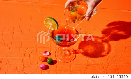 A vibrant, colorful cocktail being poured into a glass. Mixology, creative cocktails, bartender, party, celebration. 131413330