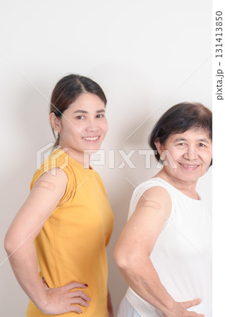 Adult and Elderly Woman with bandage after received vaccine. Vaccination and Immunization for Influenza, HPV, Zoster, IPD, DTP, Dengue, Encephalitis, Rabies, Pneumococcal Hepatitis B and Covid vaccine 131413850