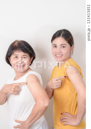 Adult and Elderly Woman with bandage after received vaccine. Vaccination and Immunization for Influenza, HPV, Zoster, IPD, DTP, Dengue, Encephalitis, Rabies, Pneumococcal Hepatitis B and Covid vaccine 131413851