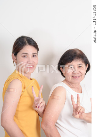 Adult and Elderly Woman with bandage after received vaccine. Vaccination and Immunization for Influenza, HPV, Zoster, IPD, DTP, Dengue, Encephalitis, Rabies, Pneumococcal Hepatitis B and Covid vaccine 131413859