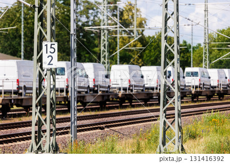 Many new modern electric and fuel cars vans transportation by cargo freight train railway wagon. Railroad export and import automotive logistics service. Safety and insurance goods shipping industry Many new modern electric and fuel cars vans transportation by cargo freight train railway wagon. Railroad export and import automotive logistics service. Safety and insurance goods shipping industry 131416392