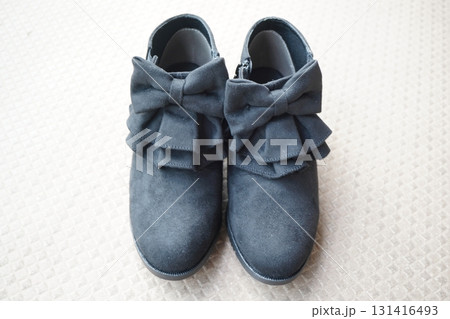 黒い大きなリボンが印象的なショートブーツを真上から撮影し左右に揃えて置いた写真素材。 131416493