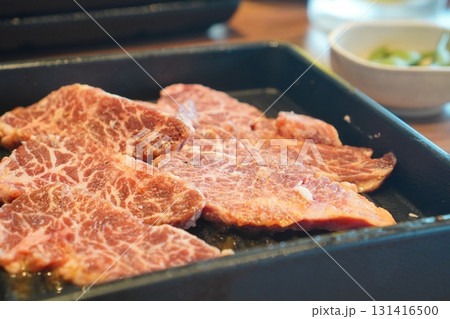 鉄板の上に並べられた霜降りの牛肉をクローズアップ撮影した食欲をそそる美味しそうな焼肉用食材 131416500