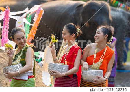 Songkran festival. Northern Thai people in Traditional clothes dressing splashing water together in Songkran day cultural festival with elephant background. Songkran festival. Northern Thai people in Traditional clothes dressing splashing water together in Songkran day cultural festival with elephant background. 131418213