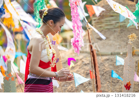 Songkran festival. Northern Thai people in Traditional clothes dressing carrying sand into temple to build sand pagoda and decoration with colorful paper flag. 131418216