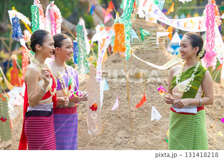 Songkran festival. Northern Thai people in Traditional clothes dressing carrying sand into temple to build sand pagoda and decoration with colorful paper flag. 131418218
