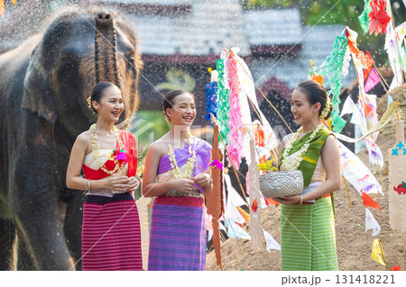 Songkran festival. Northern Thai people in Traditional clothes dressing splashing water together in Songkran day cultural festival with elephant background. Songkran festival. Northern Thai people in Traditional clothes dressing splashing water together in Songkran day cultural festival with elephant background. 131418221