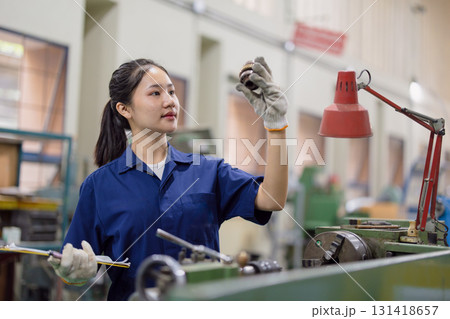 Asian women worker work in heavy industry with CNC lathe milling metal machine in steel product factory Asian women worker work in heavy industry with CNC lathe milling metal machine in steel product factory 131418657