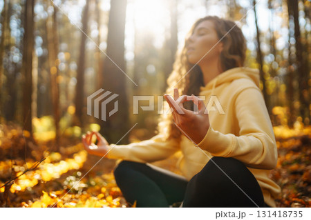 Beautiful woman practices yoga in the autumn forest. Lifestyle and meditation concept. Beautiful woman practices yoga in the autumn forest. Lifestyle and meditation concept. 131418735