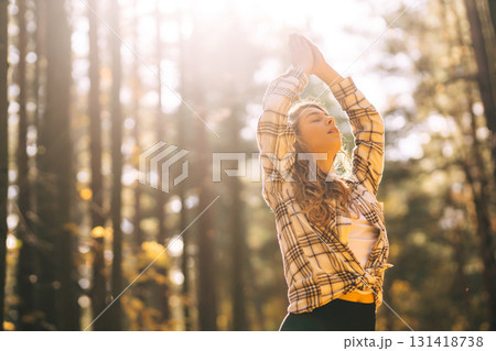 Beautiful woman practices yoga in the autumn forest. Lifestyle and meditation concept. Beautiful woman practices yoga in the autumn forest. Lifestyle and meditation concept. 131418738