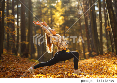 Beautiful woman practices yoga in the autumn forest. Lifestyle and meditation concept. Beautiful woman practices yoga in the autumn forest. Lifestyle and meditation concept. 131418739