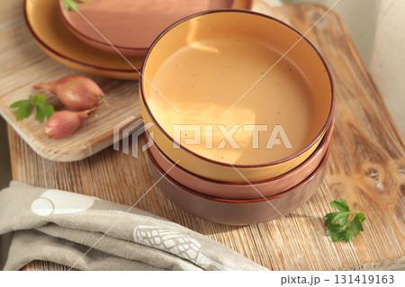 Porcelain stone plates in traditional European rustic style on wooden board with linen towel. Natural color, minimalist design. Food and farmhouse cuisine at home. Porcelain stone plates in traditional European rustic style on wooden board with linen towel. Natural color, minimalist design. Food and farmhouse cuisine at home. 131419163
