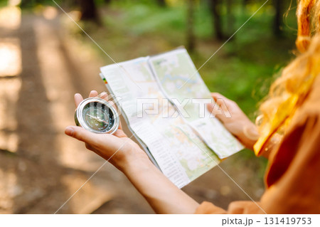 Exploring the forest with a map and compass during a sunny afternoon in a tranquil wooded area Exploring the forest with a map and compass during a sunny afternoon in a tranquil wooded area 131419753