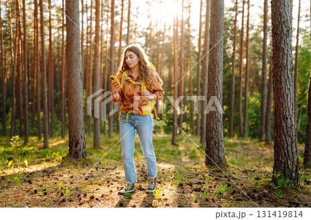 Young woman using smartphone and enjoying autumn weather in the park. Blogging, technology. 131419814