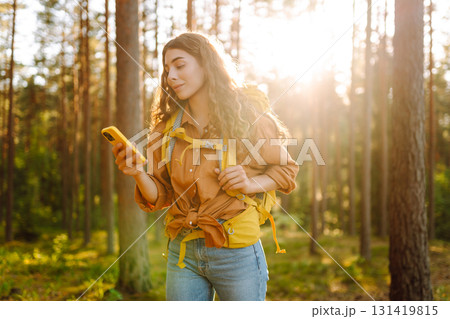 Young woman using smartphone and enjoying autumn weather in the park. Blogging, technology. 131419815