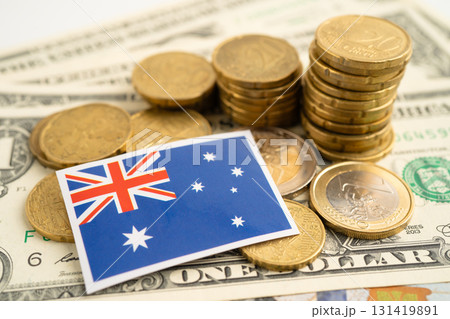 Stack of coins with Australia flag and US dollar banknotes. 131419891