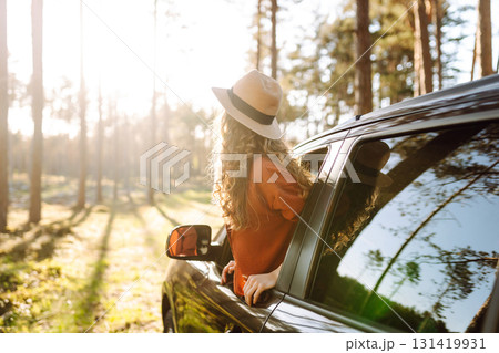 Young woman leaning out of the car window enjoying nature. Road trips summer holidays. Young woman leaning out of the car window enjoying nature. Road trips summer holidays. 131419931