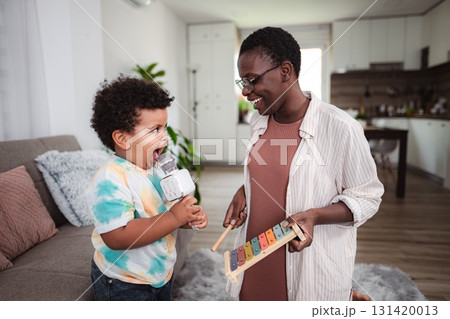 Mother and son playing music and singing at home Mother and son playing music and singing at home 131420013